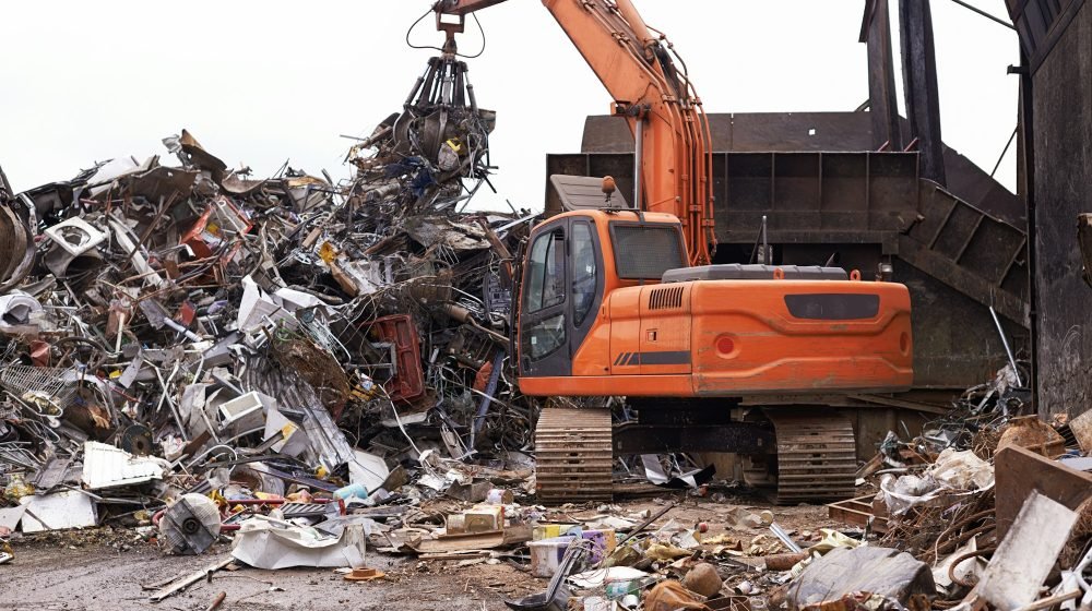 The scrapyard. Cropped shot of an excavator sorting through a pile of scrap metal.